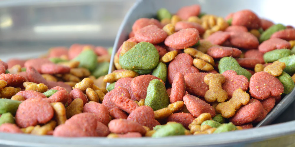 A picture of dog food being weighed out with a scoop into a bowl